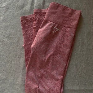 Gymshark vital  - Säljer ett par rosa gymshark vital byxor. Stl S. Fint skick, däremot har sömmen spruckit nere vid vaden (se bild 2.) går att lösa snabbt med lite sytråd!