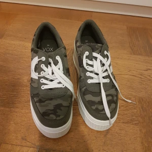 Vox Platå sneakers - camouflage - Vox platå sneakers i färgen grön/camouflage.  Storlek 39,  Aldrig använda då dem var för små och jag glömde bort att byta🙈  Finns i Norrköping