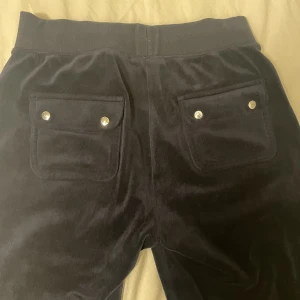 Juicy byxor  - Säljer mina mörkblå juicy byxor då de inte är i min stil❤️ Jättebra skick bortsett från att ena metallen på snöret fattas (bild 3) Nypris 1100kr