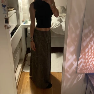 långkjol - jag säljer denna kjol. köpt på second hand men kommer aldrig till användning. den är inte så tunn i material men den är super skön och. perfekt längd. jg är 162cm Jag är en Xs. kjolen går att spänna vid midjan och den skulle då passa på en M med. 