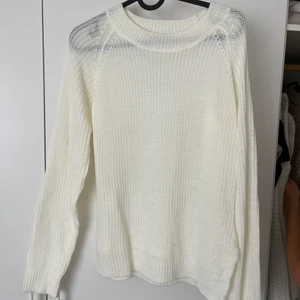 Stickad tröja  - Tunn stickad tröja med knytdetalj i sidan. 