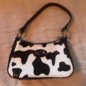 Minibag med cowprint - Jättecool Delia’s cowprint miniväska! Dragkedjan är lite trög, har några få fläckar längst ner (se bild). Annars är den i fint skick! 💕💕