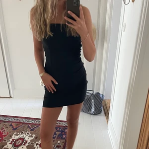 Svart klänning - Svart tube klänning med dragkedja och slits baktill. Klänningen är från bikbok och är väldigt strechig i materialet😊