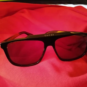 Solglasögon från Gucci - Solglasögon från Gucci (årets modell), inköpta på synsam tför ca 2.5 månad sedan, nypris ca 3300 :- Graverad logotyp, fyrkantiga bågar, tonat glas, rak skalm, böjd spets.  Märkes-ID: 681218J0740  Säljs för 2000 :-