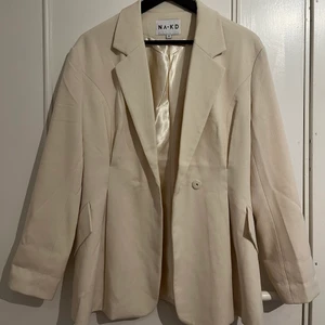 Beige/Vit blazer NA-KD - En krämfärgad blazer från NA-KD i strl 36. Aldrig använd 
