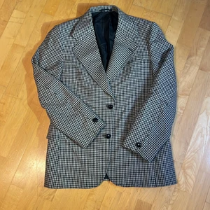 Oversize krå och svart mönstrad kavaj - Detta är en herrkavaj från Carl Axel herrmodehusen och är gjort av en ullblandning. Den va min morfars som inte är så storväxt. Jag är storlek medium och den fungerar på mig med plats för en varm tröja under. Den har fina svarta träknappar.