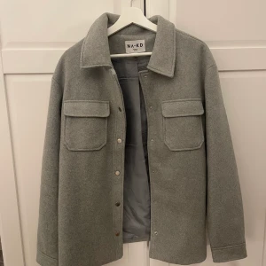 Grå kappa - Grå kappa från NA KD som är i nyskick!! Den är andvänd max 5 gånger och är köpt på zaralndo. Kappan är i storlek 38 och jättefin nu till hösten. Jag säljer den för 500kr+ frakt, originalpris 1065kr!!