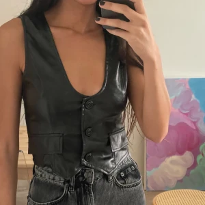 Faux läder väst - Svart fejkläderaktig väst som jag köpt utomlands i en gullig liten butik, aldrig använd. Sitter så fint på men har en liknande redan. 