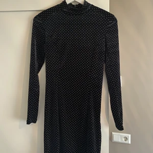 Figursydd kort sammetsklänning  - Tight kort sammetsklänning med små metallprickar. Använd 2 gånger! Vaddering i axlarna som man även kan ta bort om man vill.