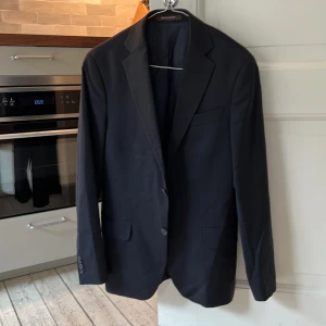 Oscar Jacobson Kavaj strl 46 - fin mörkblå kavaj från oscar jacobson, storlek 46/S (tror modellen heter Edmund). ganska bra skick, någon tråd som stack ut här och där men inget annat. behöver dock pressas :)