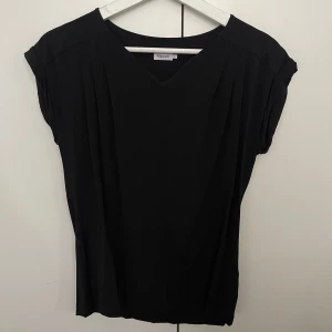 Filippa K T-shirt  - Storlek 34. T-Shirt i blusmaterial.