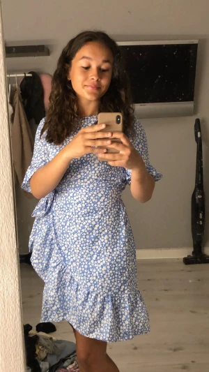 Blommig blå klänning  - Sitter väldigt fint inte för tajt eller löst. Går att spänna åt i midjan med bandet runt klänningen:) har använts cirka 2-4 gånger och har inte sett några briser på klänningen så i stort sett är den som ny💙 ( pris kan diskuteras )