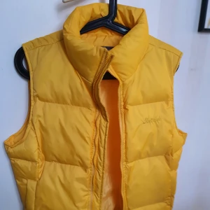 Gul väst stl.40 - Piffa upp vårgarderoben med en Gul fluffig väst(ej dun) Stl.40 i Nyskick. En Innerficka, sidofickor utan dragkedja