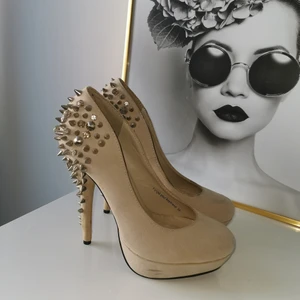 Skor med nitar - Höga klackar med silvriga nitar vid hälen. Använda ett fåtal gånger. Små "fläckar" som syns på bild. Ska nog kunna gå att tvätta av dem. Strl 39