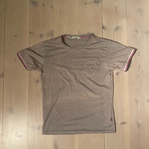 Moncler T-shirt - En snygg moncler T-shirt som ser både bra ut på killar och tjejer. Skicket är 8/10 endast lite nopprig. Den är i storlek M men är i kvinnligstorlek så sitter mer som en S i unisex. 