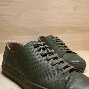 Axel Arigato, Clean 90, gröna, strl 41 - Sneakers i modellen Clean 90 från Axel Arigato. Tidlös design med en subtil logotyp i guldton. Skorna är riktigt fräscha, bra skick på läder och sula och inga skador eller fläckar. Sparsamt använda och alltid välskötta, känns som nya. Storlek: 41. Färg: Mörkgrön (Khaki Green). Nypris: 1950 kr (2019). Skick: Mycket bra. Dustbag och kartong: Nej. 100 % läder. Läderfodring. Gummisula. Handgjorda i Portugal.