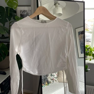 Vit topp med knytning i ryggen - Vit topp i bomull med snörning baktill. Jättefin till antingen kjol eller byxor och går att bära både till vardags eller fest. 