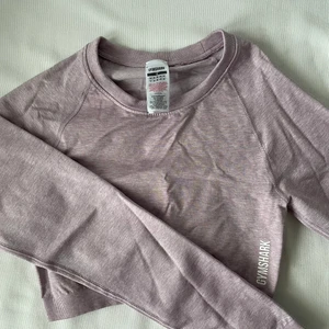 Träningstopp Gymshark  - Kort träningstopp som använts en gång. Tajt modell med detalj bak. Ser grå ut på bilderna men är mer lila i verkligheten. 