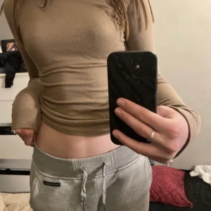 Tröja - En beige fin polo tröja från Nelly! Tröjan är i ett bra sick och har ej några märken eller fläckar⚡️⚡️ Tröjan är i storlek s och säljer för 50kr✨✨På bild två ser ni den riktiga färgen