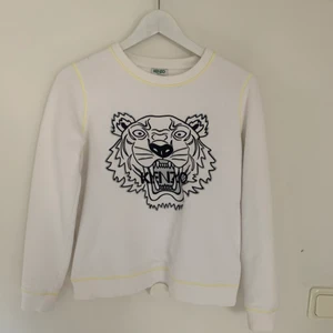 Kenzo tröja  - Fin kenzo sweatshirt i vit med gula detaljer. Super fin till sommaren. Knappt använd. Nypris runt 2000kr storlek S men liten så skulle säga att den mer passar en xs