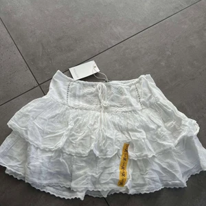 Vit shortskjol i spets - Säljer nu min ickeanvända, vita, shortskjol i spets! Den är är aldrig använd och har prislappen kvar, säljs pågrund av att den var förliten för mig!🥲❤️