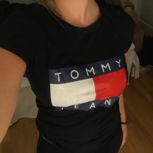 Tommy Hilfiger T-shirt från kollektionen Tommy Jeans. Väldigt stretchig så passar allt från en oversized XS till en tightare M. Nypris 339 kr.  Jag är 169 cm lång och strl M som referens. Köparen står för frakt (66 kr) eller möts upp i Linköping<3