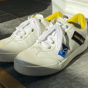 Calvin Klein Seakers  - Snygga bekväma fashion sneakers i vitt läder. Skorna är i riktigt bra skick och använda sparsamt. Säljes enbart pga Platsbrist. Strlk 42 men relativt rymlig modell. Nypris ca 1300kr BVSA!! 