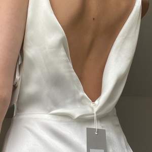 Säljer nu denna helt nya klänning perfekt till studenten, i vit satin. Storlek S. Lappar kvar!