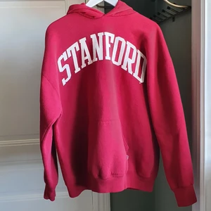 Stanford hoodie! Knall röd och inte råsa - Här är en knallröd stanford hoodie i lite baggy fit. Den ser råsa ut på bilderna men är vanlig röd, har med ljuset på bilderna att göra. Köpt för 600 kr. Fint skick inga fläckar!