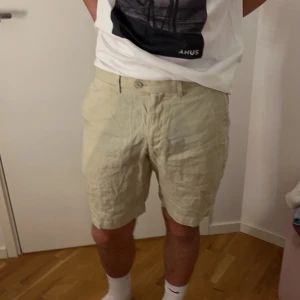 Beiga linneshorts - Hej, säljer dessa beiga linneshorts till mig pojkvän. Han säljer pga använda inte löngre, köpta förra sommaren i Spanien och är i fint skick. Han är 182 cm, storleken är 44, skulle säga att de sitter som M på honom. De är mer beiga än vad de ser ut att vara på bilden. Nypris 400kr och säljer för 200kr