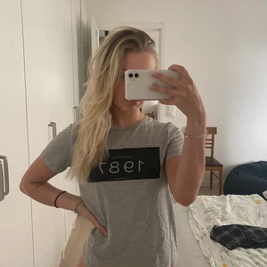 T-skirt från vero moda - Säljer grå t-skirt från vero moda i strl M, passar S🌸 med tryck 1987 på💗 köpte för 299kr, säljer för 30kr💗 kan mötas i Sthlm eller fraktas🌸