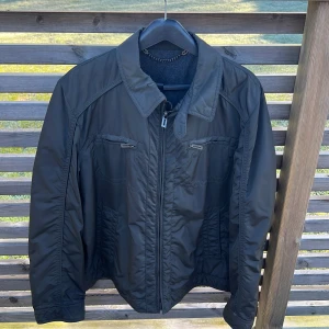 Men’s jacket black (never used) - Black men’s jacket for spring/summer. Thin woolen lining with two side pockets and inner wallet pocket. Waterproof outer fabric. Brand new, never used.