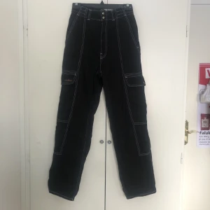 CARGO BYXOR - Svarta cargobyxor med vita sömmar från Urban Outfitters. Köpta för ca 600 kr. Skriv om du vill ha fler bilder eller har frågor! Köparen står för frakt. Kan även mötas i Stockholm