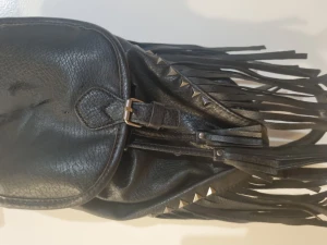 Liten väska i skinn.  - En liten snygg fejkskinn väska med fransar och detaljer 