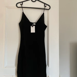 Klänning med glitter  - Fin klänning med glitter, aldrig använd. Prislapp kvar! 