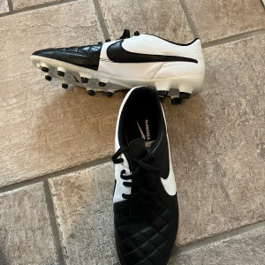 Nike Tiempo Svart/Vit strl 43 - Nike Tiempo i storlek 43.  Inte använda så mycket och därför i ganska bra skick.  