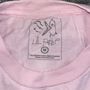 Lil peep t-shirt  - Bebisrosa t-shirt från lil peep. Tyvärr aldrig använd pga köpte fel storlek. Kan gå ner i pris vi snabb affär 🥰