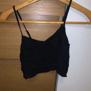 Topp  - En svart topp från hollister i storlek xs. Aldrig använd och inga defekter. Säljer för att den är för liten för mig. 