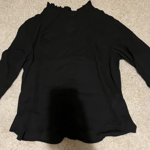 Svart blus från Gina Tricot  - Denna blus är i ett tunt blusantigt material med volangärmar och i  kragen! Köpt från Gina Tricot i strl 34 och använd vid ett tillfälle 🥰