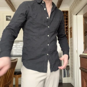 L’homme rouge skjorta - Svart skjorta i tencel-tyg från l’homme rouge. Tappat lite färg i tvätten, mer antracit-färgad nu, men fortfarande lika snygg. Kan samfrakta