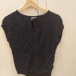 Vero Moda, XS - En snygg mörkblå blus i st XS men passar även en S. Den har en liten öppning över bröstet med en knapp. Den är i bra skick. 60kr+frakt 