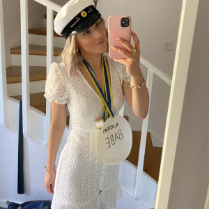 Studentklänning - En vit klänning med brodyrdetaljer som jag endast har använt 1 gång. Både fin och bekväm, den satt bra på och åkte ej upp under utspringet😁 