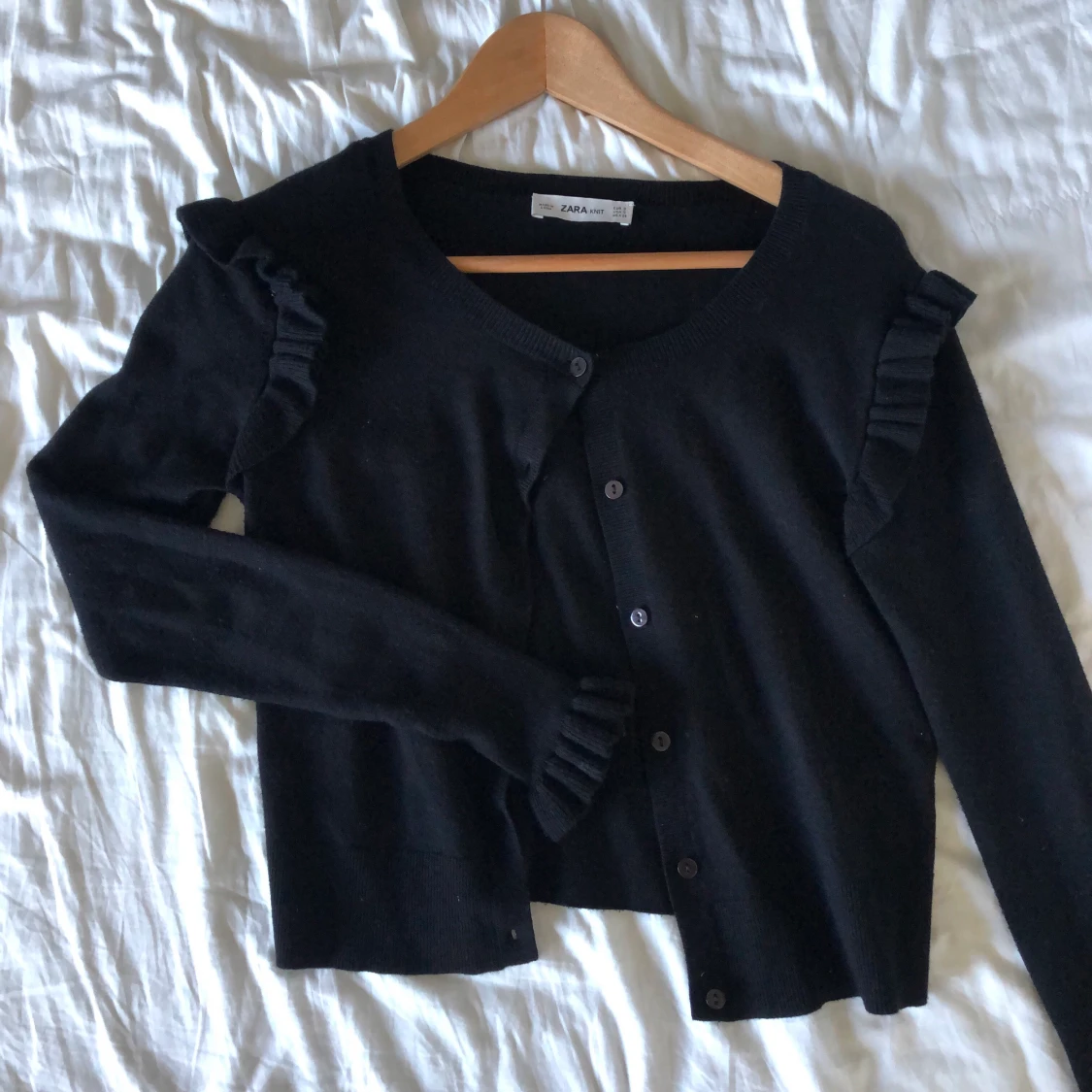 Finstickad kofta med volanger