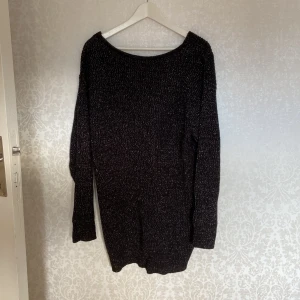 Glittrig stickad klänning - Glittrig stickad klänning  Stl M  V-ringad i ryggen men man kan nog använda v-ringningen framåt om man vill ha det så😃  Hund finns i hemmet