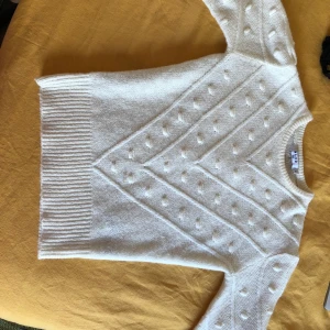 Stickad tröja - Vit, stickad, smickrande tröja med lite puffiga armar. Superfin och sitter bra och smickrande! 