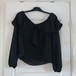 Volangblus från Gina Tricot - Fin svart volangblus i storlek 40, skulle även passa 38.