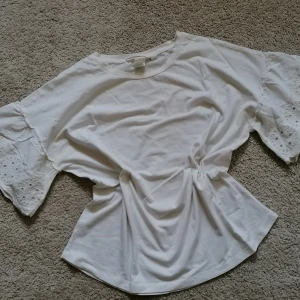 T-shirt - Elegant T-shirt with English embroidery on the sleeves. Made of 100% cotton. 