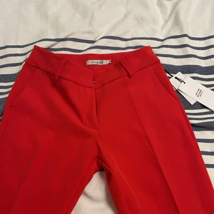 röda kostymbyxor - vida röda kostymbyxor från danska märket design by si. har flera olika kostymbyxor därifrån som är skitsnygga. dessa var dock lite för korta för mig, är 175. skulle nog passa någon som är 170 och under. 