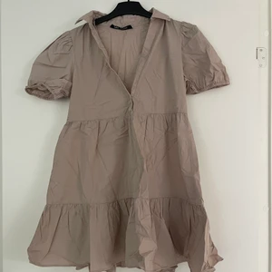 Beige klänning  - Klänningen har används en fåtal gånger men är så gott som ny, klänningen har en liten urigning som går utmärkt att knäppa. 