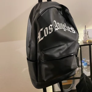 Väska  - En helt ny väska , svart och man får plats med hel del saker inne. De finns även fack utanför väskan men även i den. 